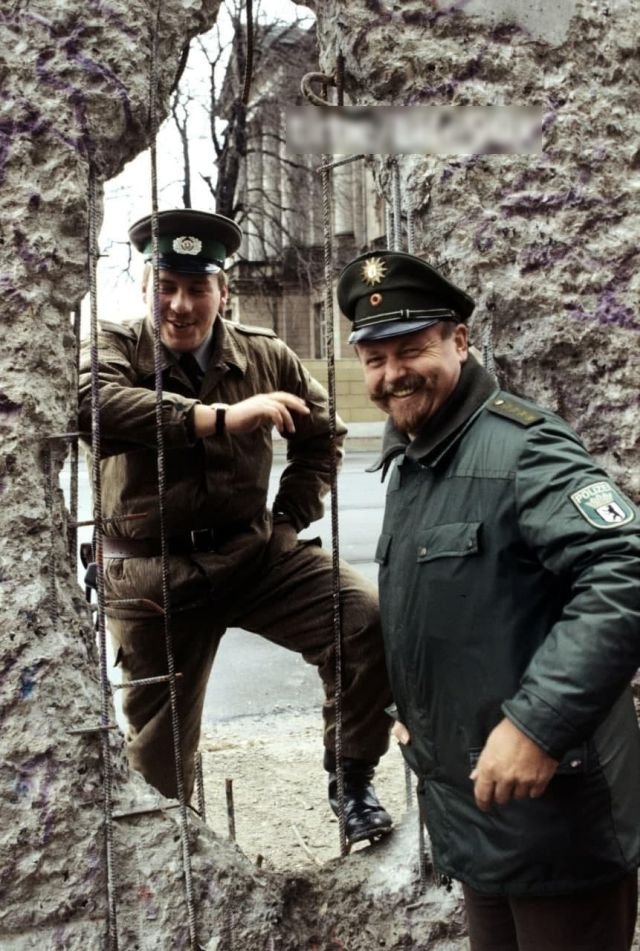 Пограничник ГДР и полицейский ФРГ у Берлинской стены, 1990 год.