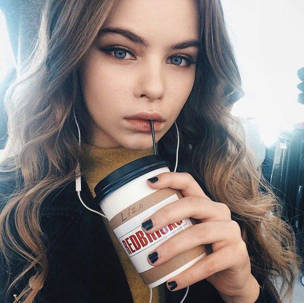 Молодая девушка пьет кофе.